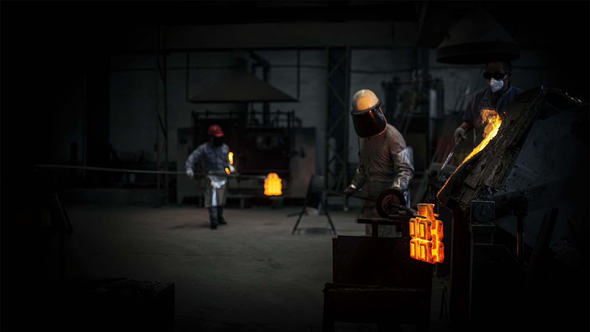 Foundry workers pouring molten metal
